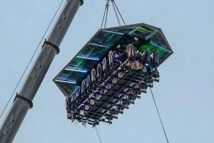 Guests on the suspended FlyDining platform beneath a cloudy daytime sky